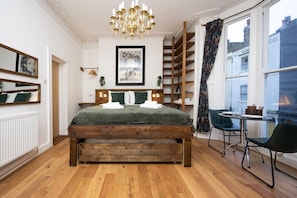 Relax in this inviting bedroom with a large bed, wooden headboard, and a window offering a view of the outside.