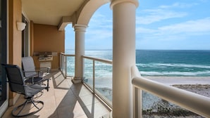 A balcony with a view of the ocean, a grill, and two chairs. - Portofino Island Resort 3-1903 (Pensacola Beach)