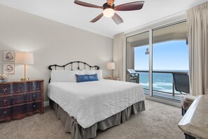 Ein Hotelzimmer mit Bett, Schminktisch, Schreibtisch und Blick auf den Ozean.