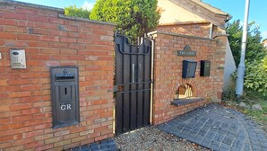 A brick building with a black gate, a post office, and a mailbox labeled "GR". - Cozy 1 bed with countryside views near Peterborough (Yaxley)