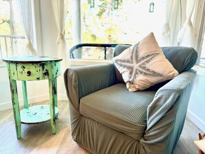 A chair with a cushion and a small table beside it.