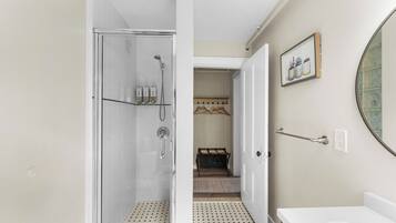 A bathroom with a shower, a sink, and a mirror.