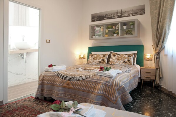 Camera d'hotel con un letto, un comodino, uno specchio, una finestra e vista sulla città.