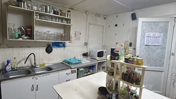 Een koelkast met diepvriezer, een microgolfoven, een oven, een kookplaat