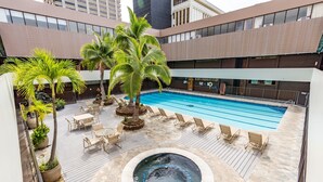 Una piscina interior con sillones de descanso y palmeras.