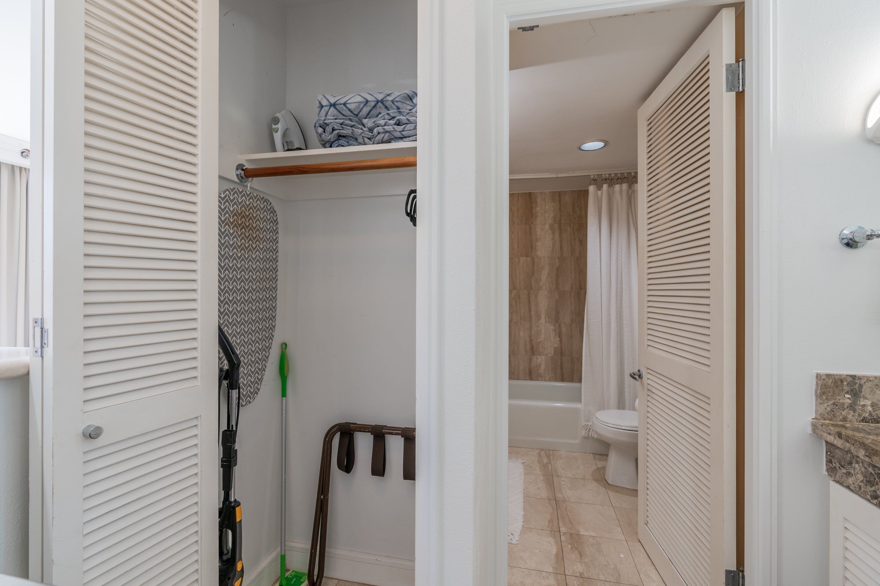 A bathroom with a shower, toilet, and a towel rack.
