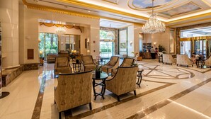 A spacious lobby with high ceilings, chandeliers, and patterned furniture. - 🍧 Summer Special - Royal Garden Waikiki - Ocean View - Resort Amenities 😎 (Honolulu)