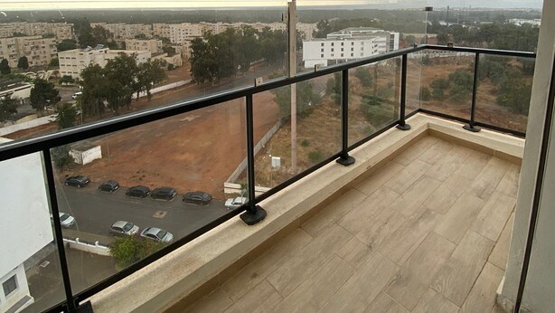 Un balcon offrant une vue sur le paysage urbain, avec des bâtiments et une rivière.