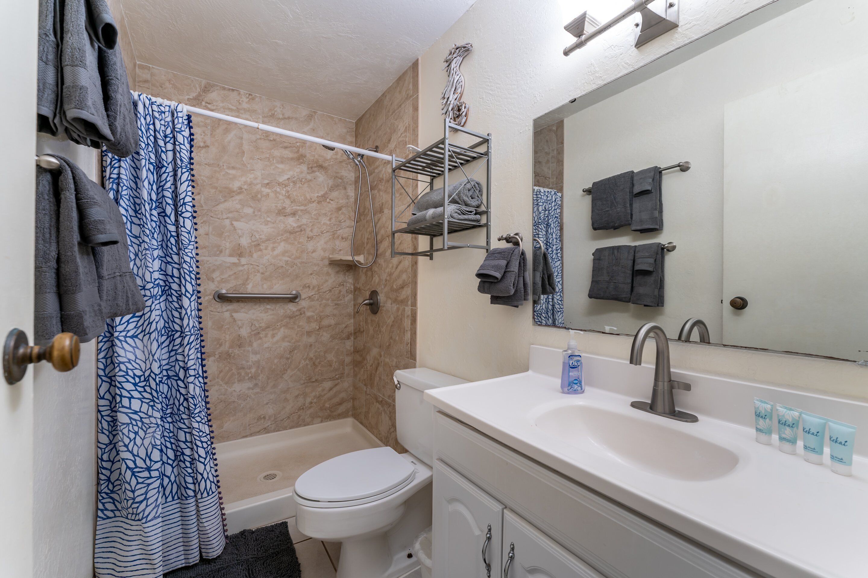 Un baño con bañera, inodoro, lavamanos y perchero para toallas.