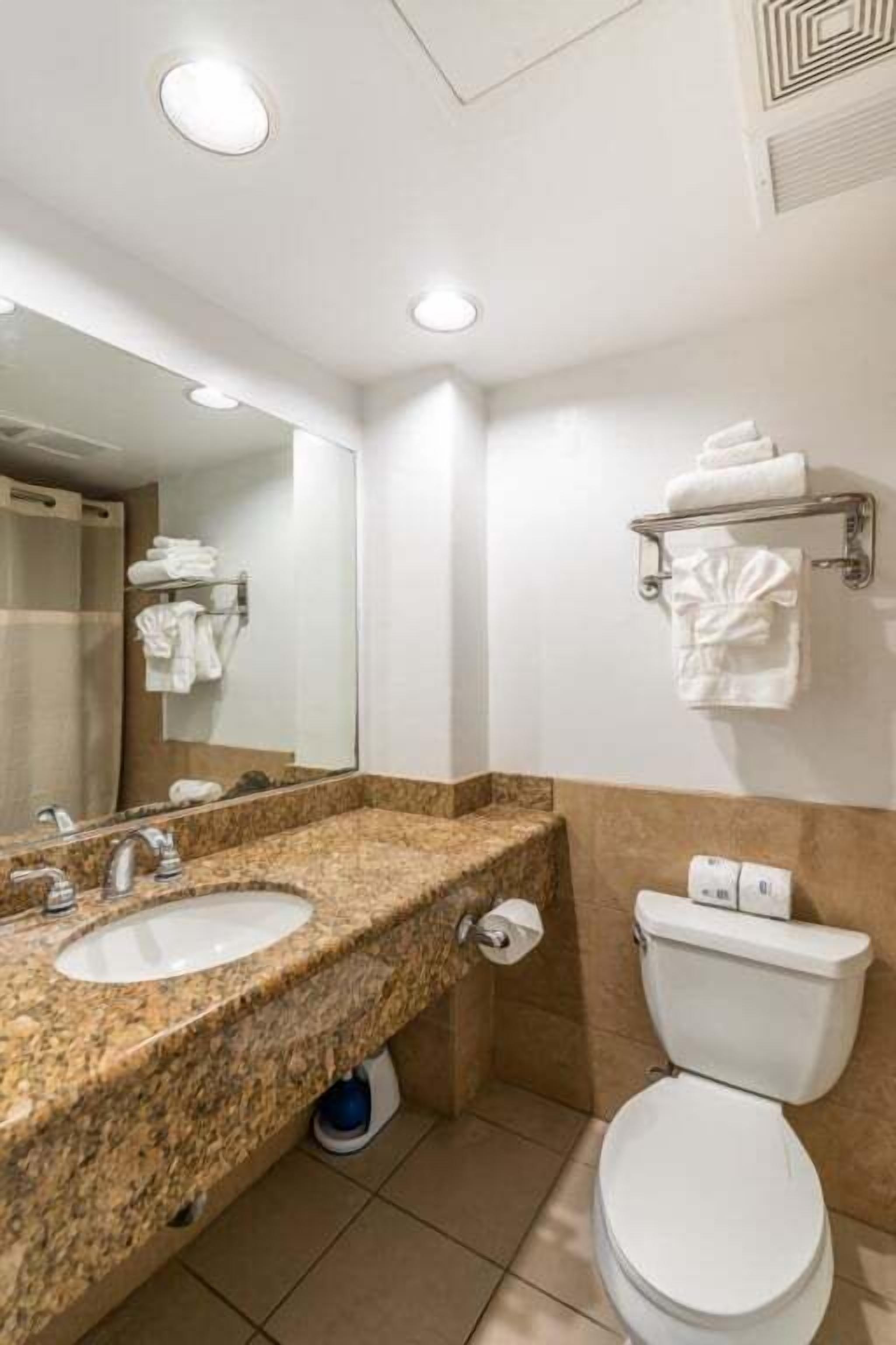 A bathroom with two sinks, a toilet, and a towel rack.