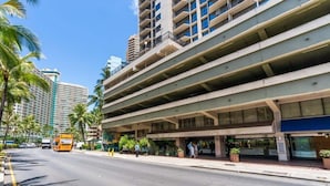 Un parking à plusieurs étages, doté d’une passerelle couverte et d’une entrée d’hôtel.