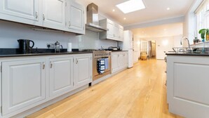 Een moderne keuken met witte kasten, een centraal eiland en een ingebouwde oven.