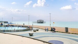 A beachside promenade with a swimming pool, a pier, and a flag. - Host Stay Sea View Oriental Place (Brighton)