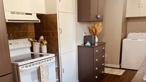 Eine moderne Küche mit weißen Schränken, einem Backofen und einer Mikrowelle.