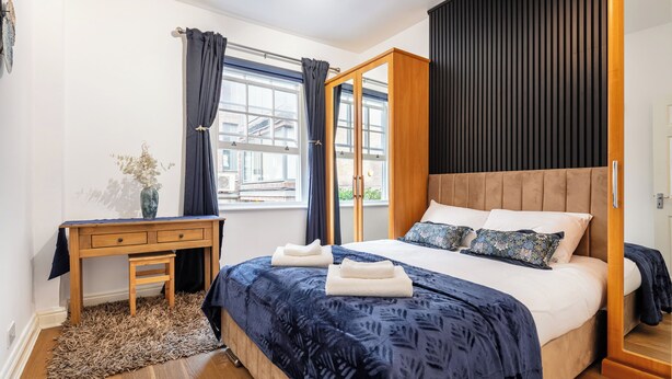 A bedroom with a bed, a desk, and a window. - |Elegant Three Bed Apt in The Heart of Marylebone| (London)