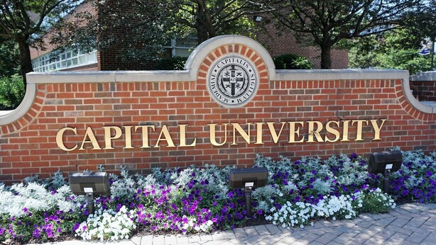 A brick wall with the words "CAPITAL UNIVERSITY" in large letters, a crest above the text, and a flower bed in front. - #33 Nice stay near Bexley and Capital University (Columbus)
