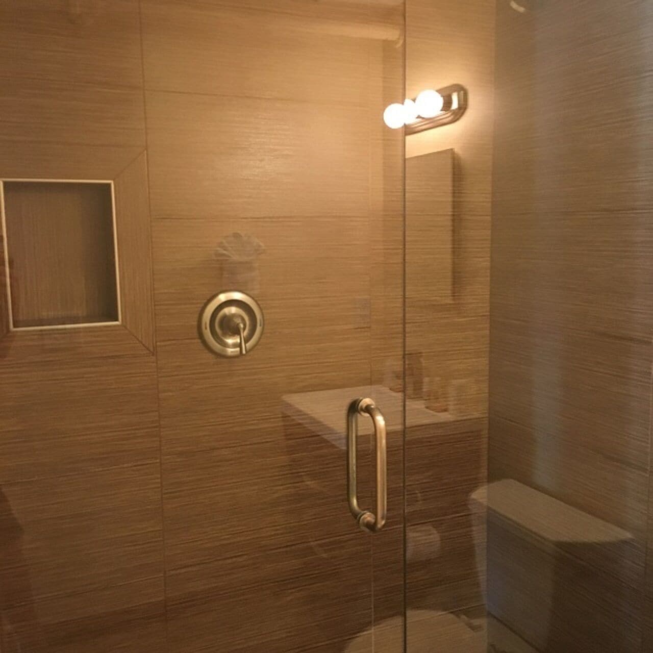 Une salle de bain moderne dotée d’une douche à parois de verre, de toilettes apparentes et d’un lavabo avec un miroir.