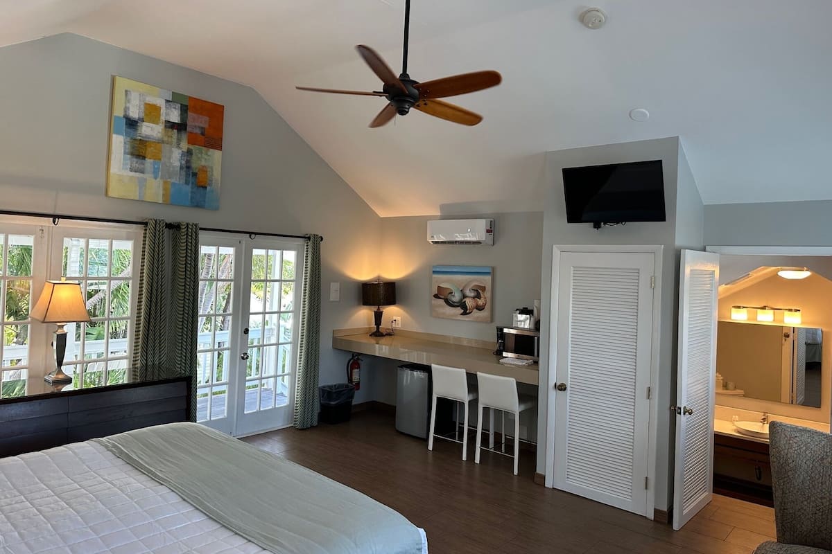 A bedroom with a bed, a desk, and a TV.