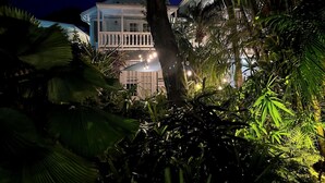 A large, two-story building with a balcony, surrounded by dense tropical foliage. - Douglas House - Adults Only (Key West)