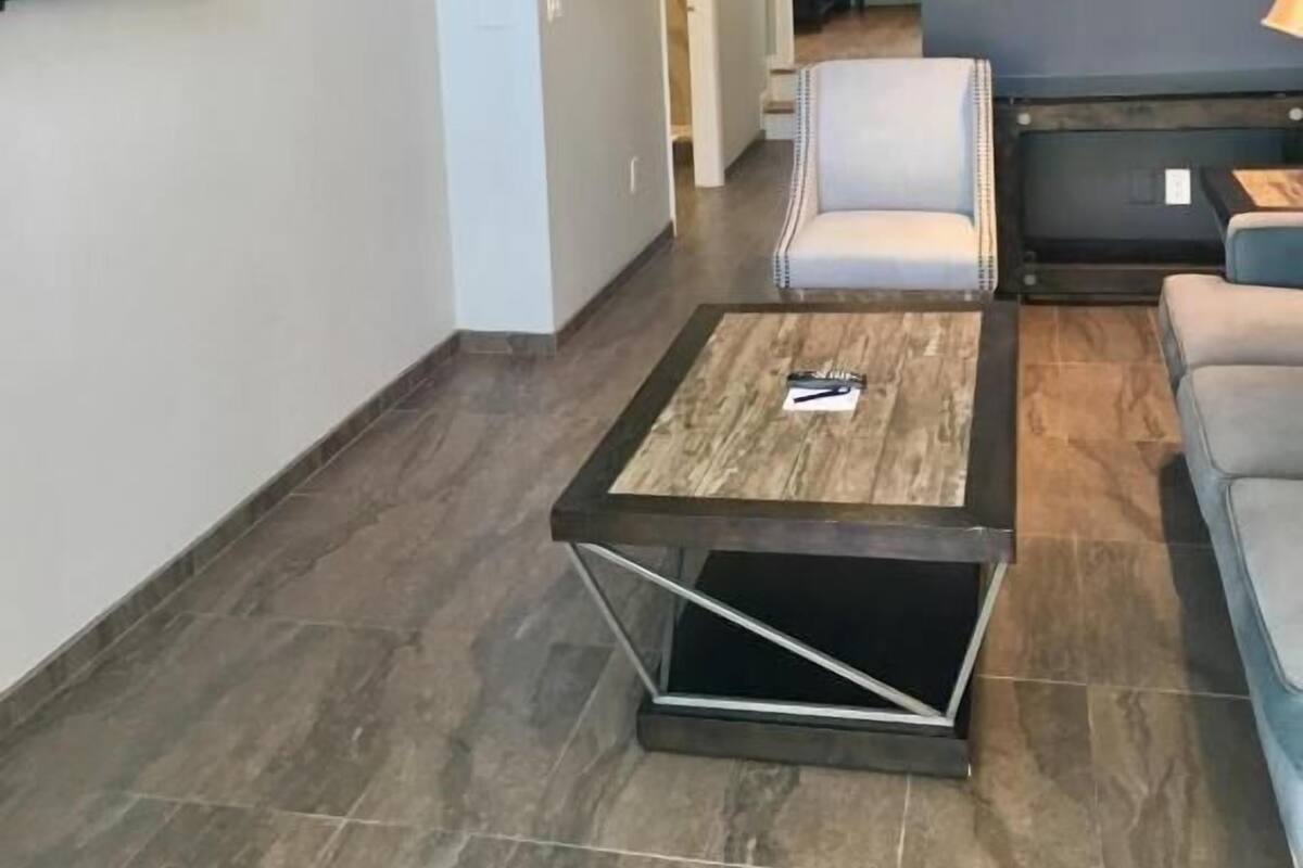 A modern living room with a flat-screen TV, a coffee table, a sofa, and a painting on the wall.