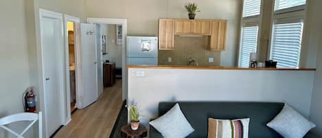 A modern kitchen with wooden cabinets, a built-in fridge, and a small dining area with a table and chairs.