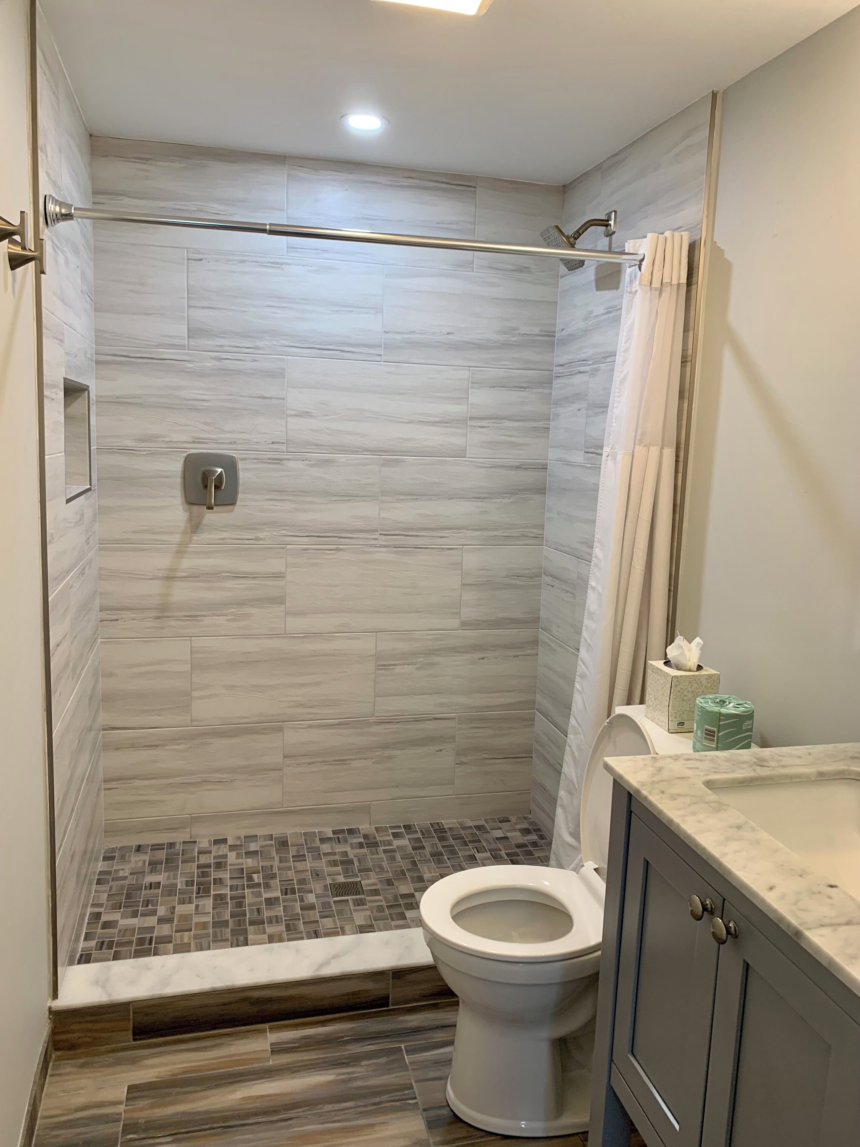 Un bagno moderno con doccia, servizi igienici e lavabo.