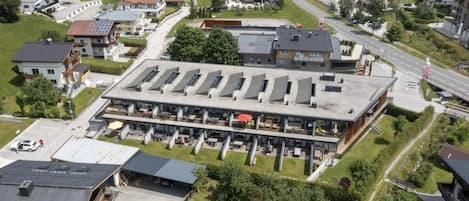 Un grand immeuble à étages, avec un espace de stationnement et une route à proximité.