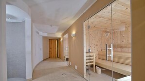 Un pasillo con zona de sauna, paredes de madera y una partición de vidrio.