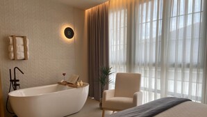 A modern bathroom with a freestanding bathtub, a towel rack, and a potted plant. - Hotel Puerto de Luarca  (Valdes)