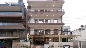 A multi-story hotel with a central entrance, balconies on each floor, and a gated driveway. - The Lodgers Hotel and Banquet Sector 38 (Gurugram)