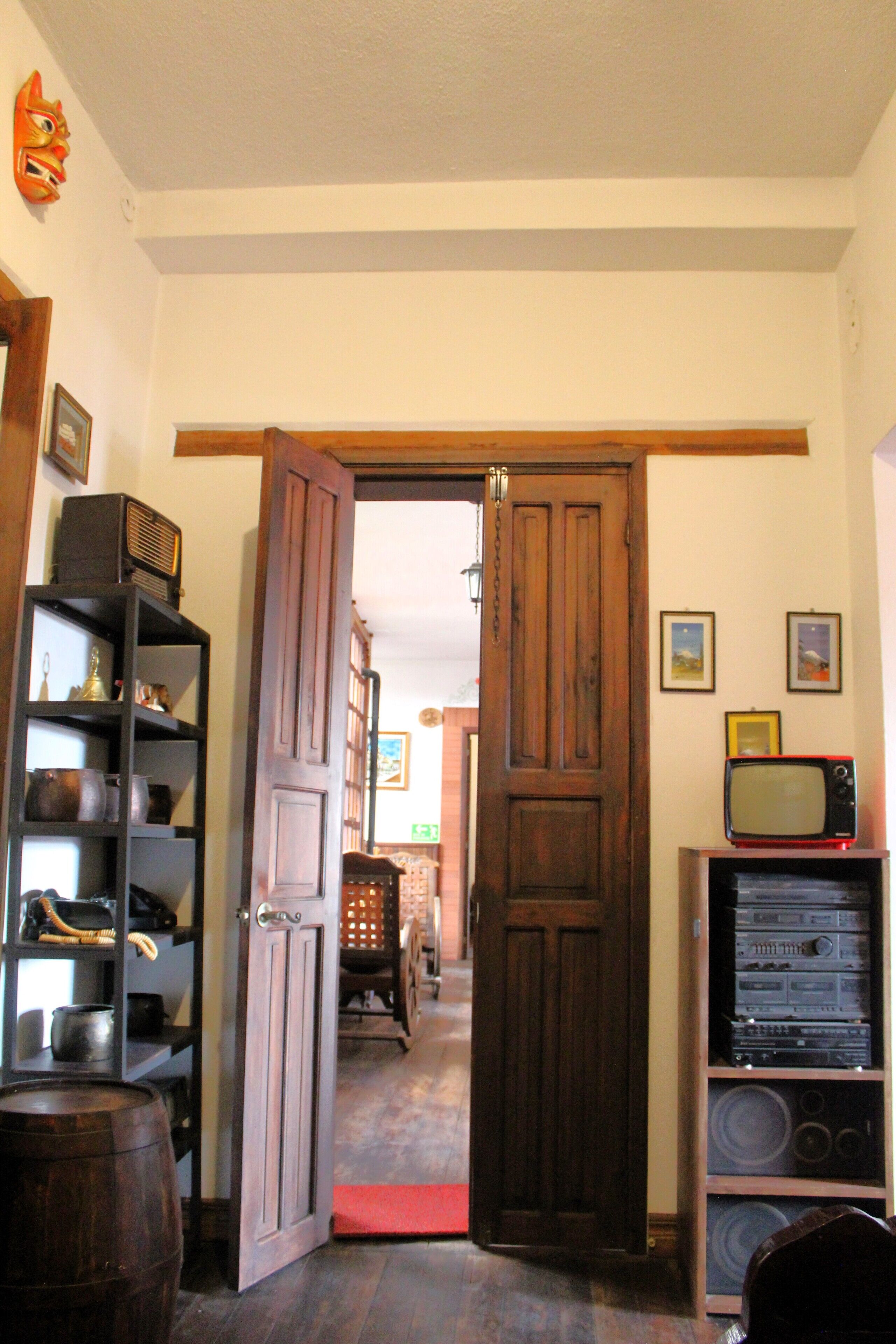 A room with a wooden door, a bookshelf, and a television.