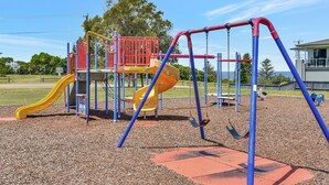A playground with slides and swings. - Ocean Mist at Caves Beach Villas (Caves Beach)