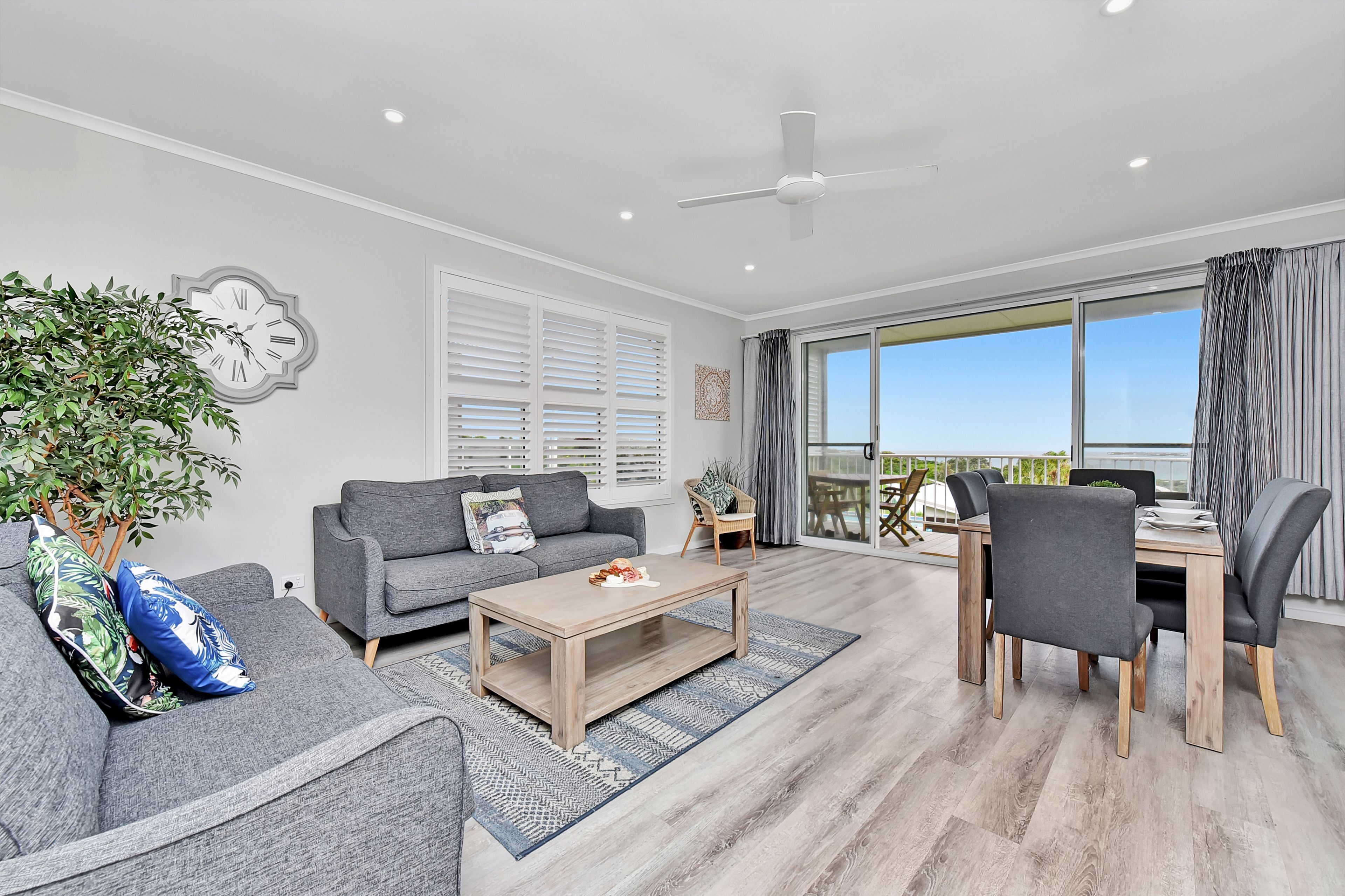 A modern living room with a sofa, coffee table, and dining area.