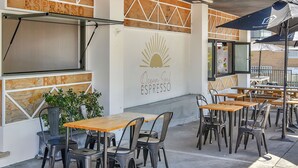 An outdoor seating area with tables and chairs, a sign reading 'Ocean Soul Espresso,' and a menu board titled 'Wild.'