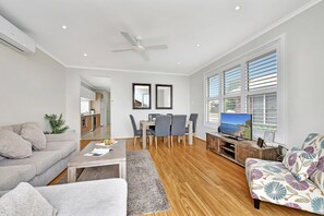 A modern living room with a sofa, coffee table, and TV area.