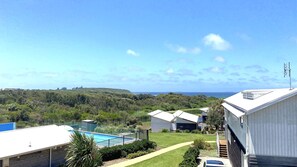 Zona residencial con piscina, vista al mar y paisaje montañoso.