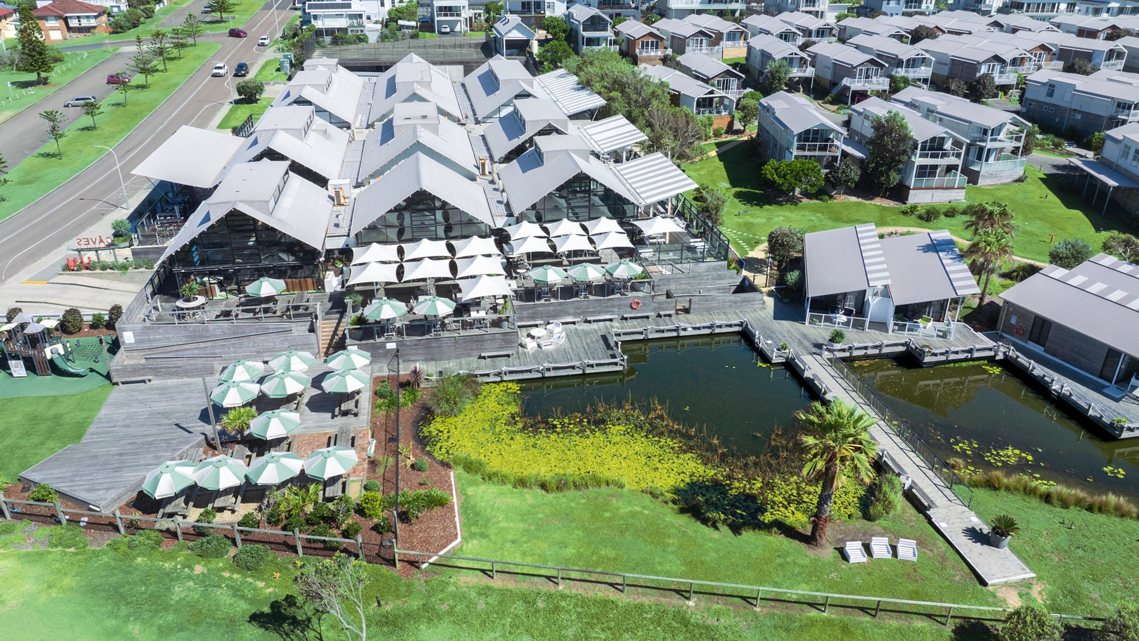A residential area with modern houses, a dock, and a small pond.