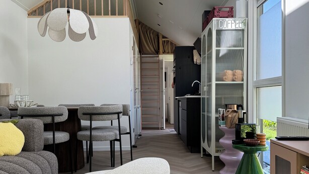 A modern living room with a high ceiling, skylight, and a dining area with a table and chairs. - 3bedroom, heated pool, 20min to beach, kidsproof (Heinkenszand)