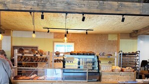 A bakery with wooden interior and a display case filled with baked goods. - 3bedroom, heated pool, 20min to beach, kidsproof (Heinkenszand)