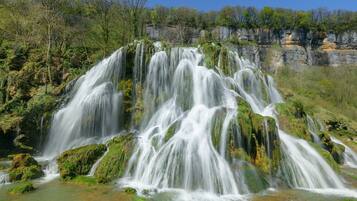 A waterfall cascading over rocky terrain with lush greenery around.