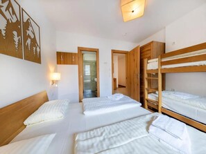 Ein Zimmer mit Etagenbetten, einem Holzschrank und einer Wandleuchte.