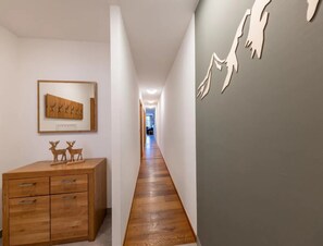 Ein Flur mit Holzboden, einem Holzkabinett mit Schubladen und einem gerahmten Bild an der Wand.