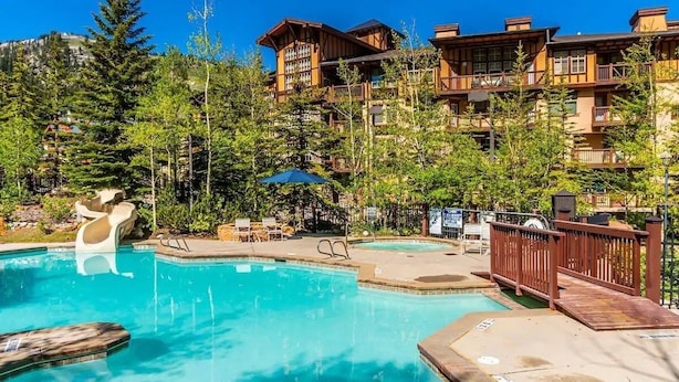 A resort with a pool, lounge chairs, and a wooden deck. - 4 bdr Swiss chalet in Solitude, 5 min to lifts (Salt Lake City)