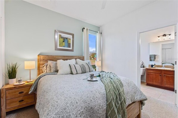 A bedroom with a bed, bedside table, lamp, and a view of the bathroom. - 4BR Pool Villa with Spa, Near Disney - Gated Resort! (Kissimmee)