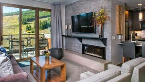 Ein modernes Wohnzimmer mit einem Flachbildfernseher über einem Kamin, einem Sofa und einem Couchtisch.
