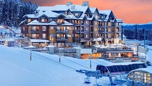 Ein großes Chalet mit mehreren Balkonen und einer Seilbahn im Vordergrund.