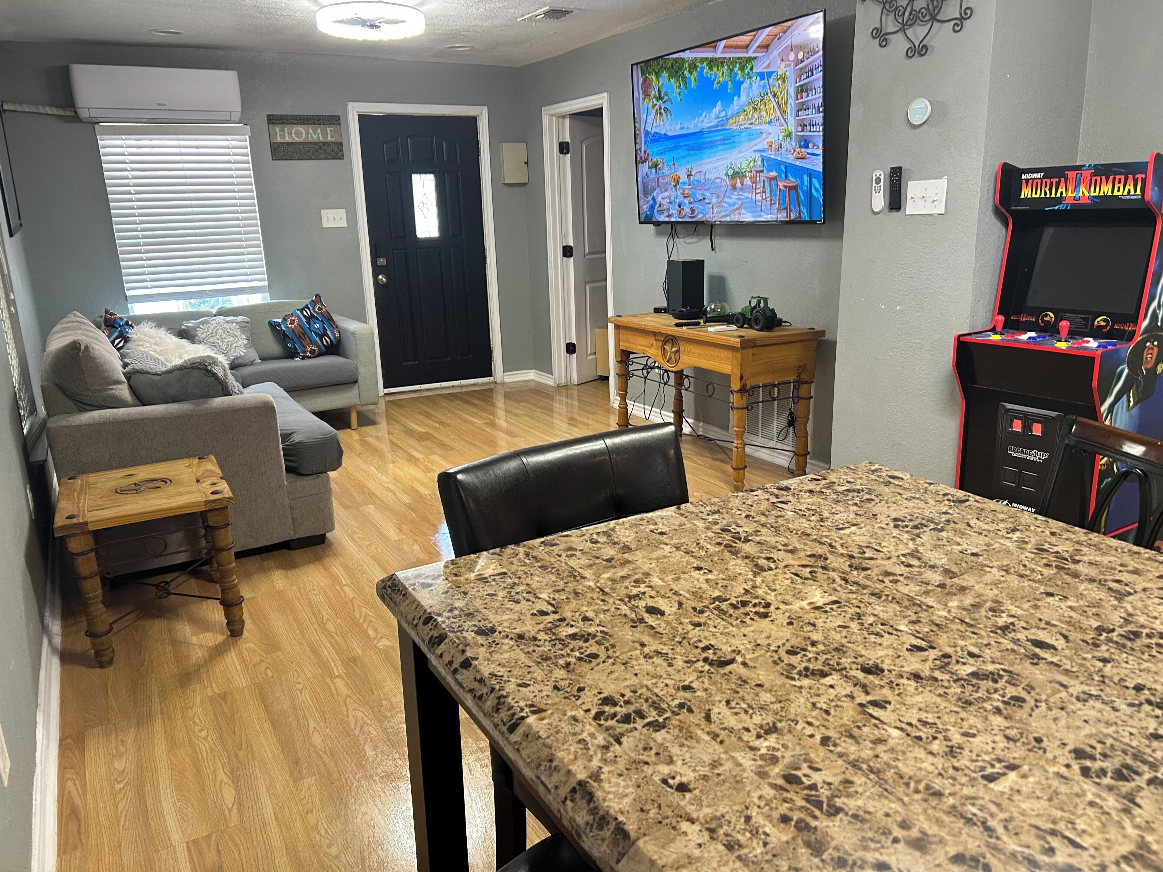 Una sala de estar con televisor, una zona de bar y una mesa de comedor.