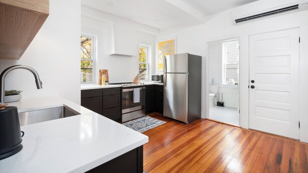 A modern kitchen with a white countertop, stainless steel appliances, and wooden flooring. - Fox Point 3BR - Near Brown, RISD & Downtown (Providence)