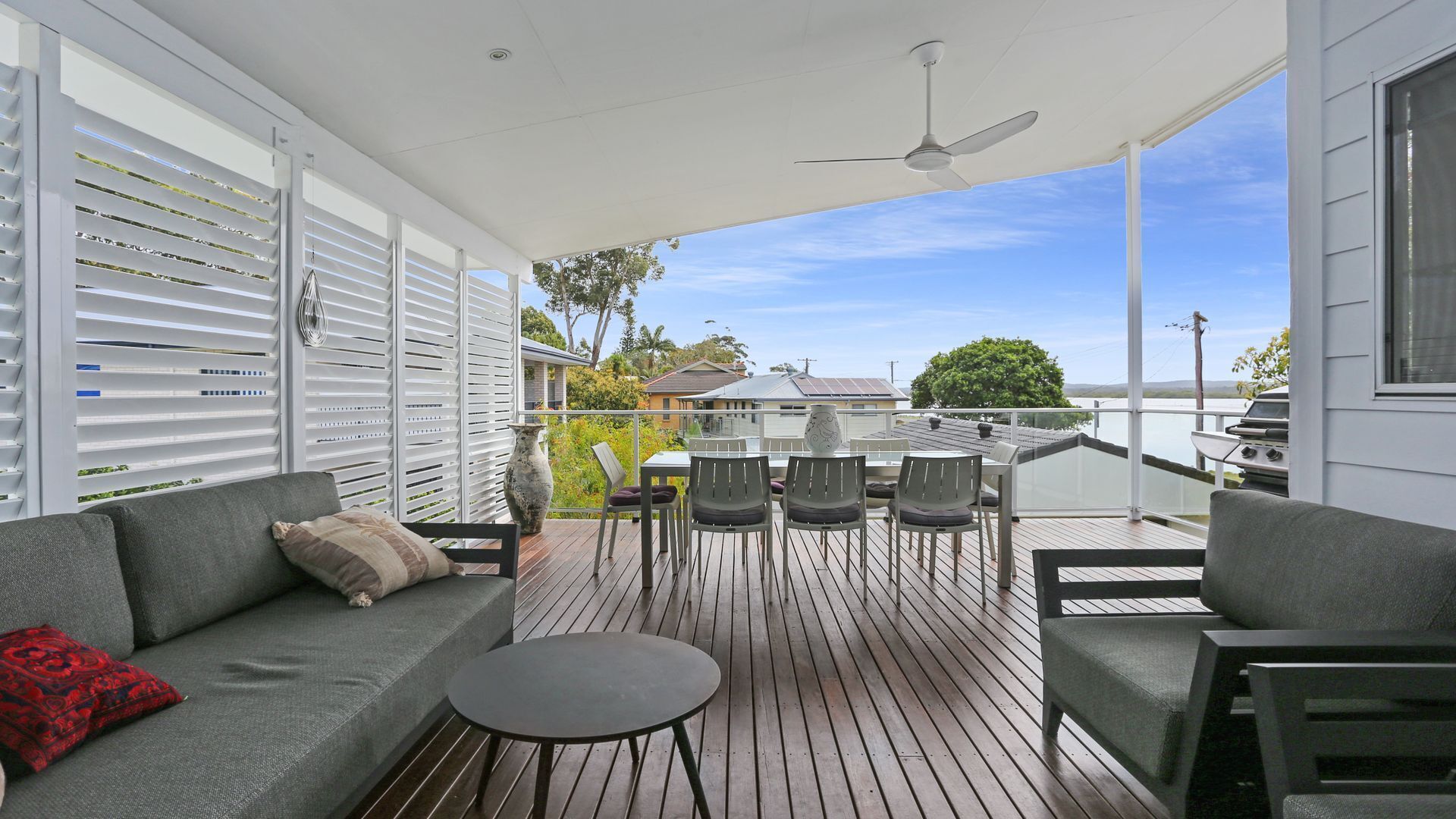 Une terrasse extérieure avec un canapé, des chaises et une table.