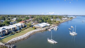 Stunning coastal homes line the marina, surrounded by lush greenery and a serene waterfront.